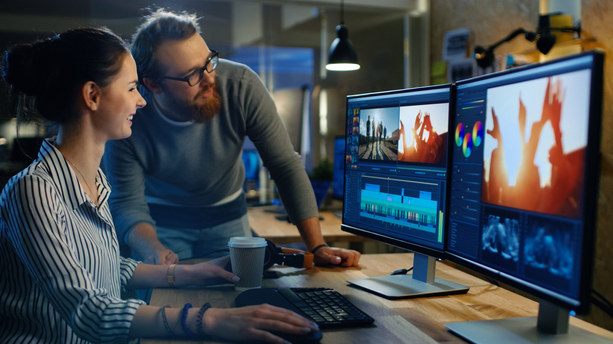 female and male video editors choosing the frame images for a large video project