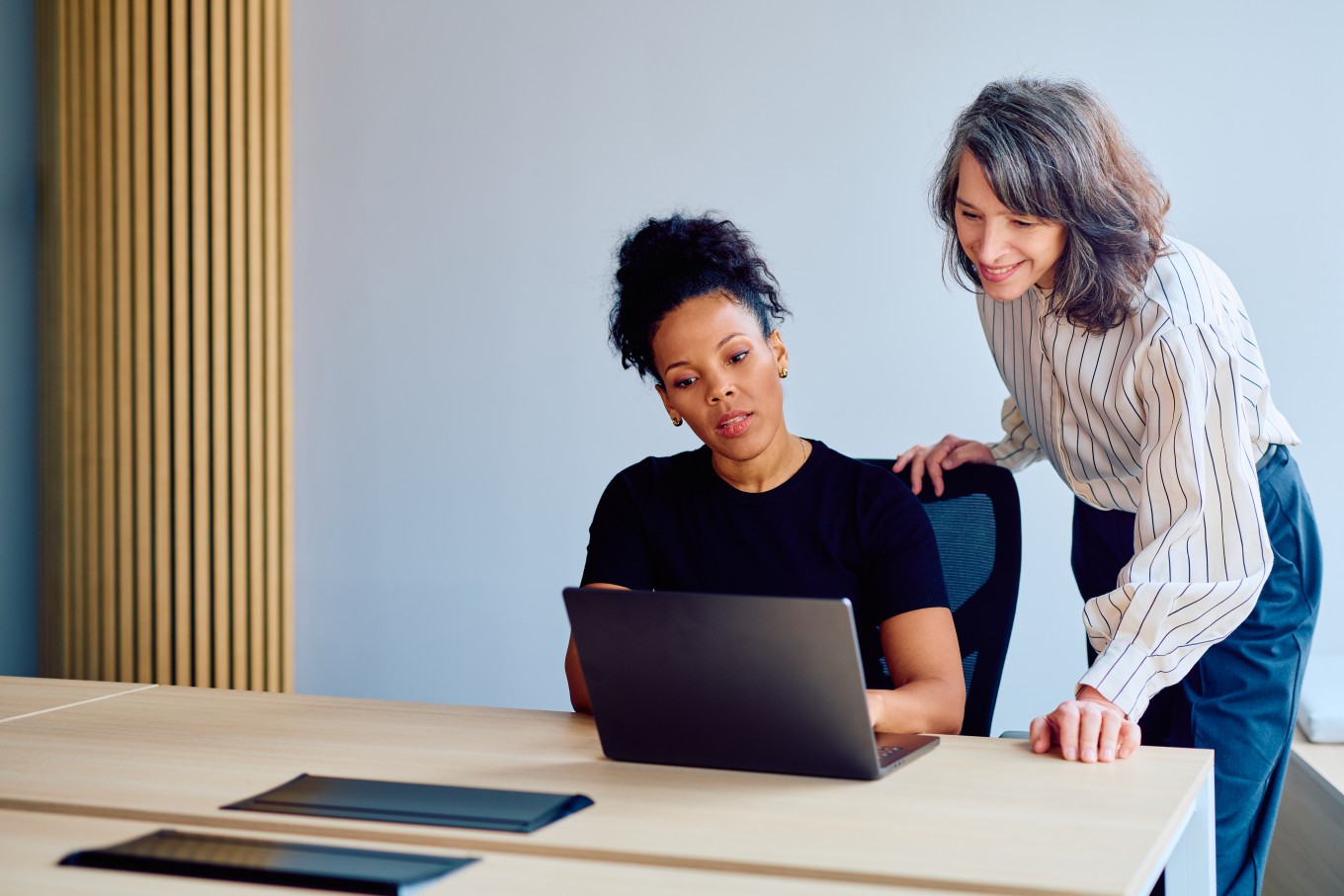 Two finance professionals reviewing career progress together, reflecting the mentoring and support available on the AAT Level 4 Diploma for Professional Accounting Technicians