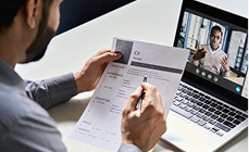 Man checking a payroll document beside his laptop Man checking a payroll document beside his laptop